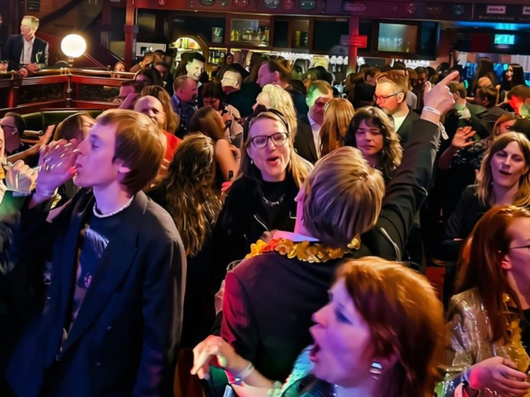 Gäster sjunger och dansar tillsammans under en karaokekväll.