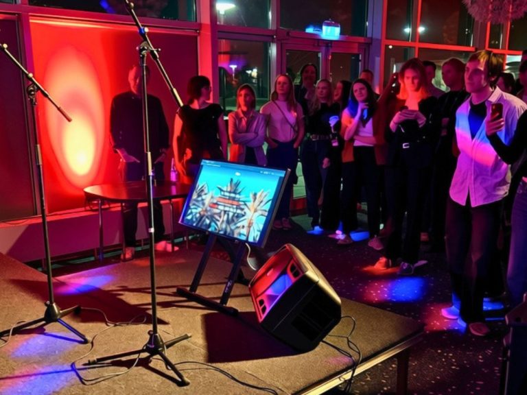 Karaokeutrustning med TV, mikrofoner, golvmonitor och festbelysning.